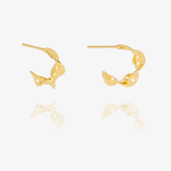 A pair of gold hoop earrings with a twisted, organic abstract design, displayed on a clean white background with a soft reflection below.