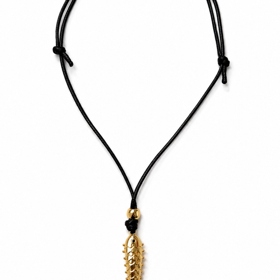 Product shot of black cord necklace with a gold fish pendant.