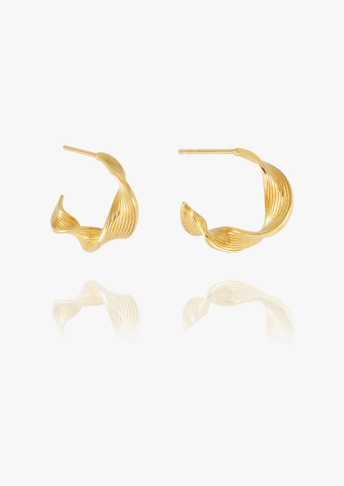 A pair of gold-toned twisted hoop earrings with a textured, ribbed surface, displayed on a clean white background with a soft reflection below.