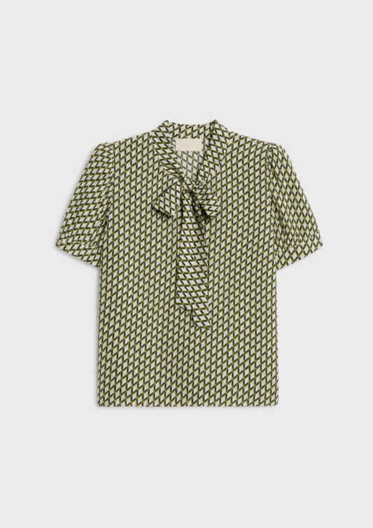 flat lay of a green geometric blouse on a plain background