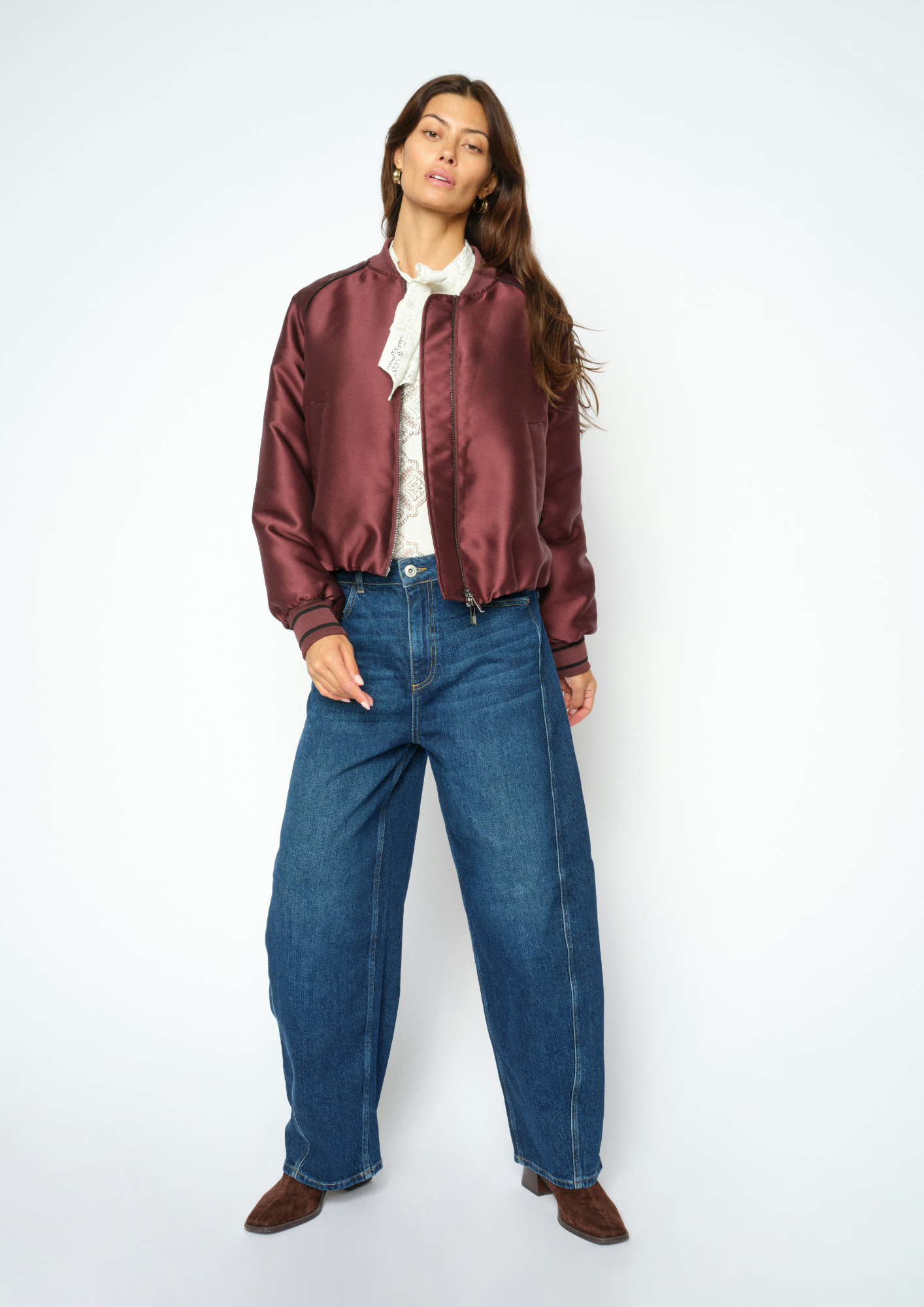 Woman wearing blue jeans and a purple coat