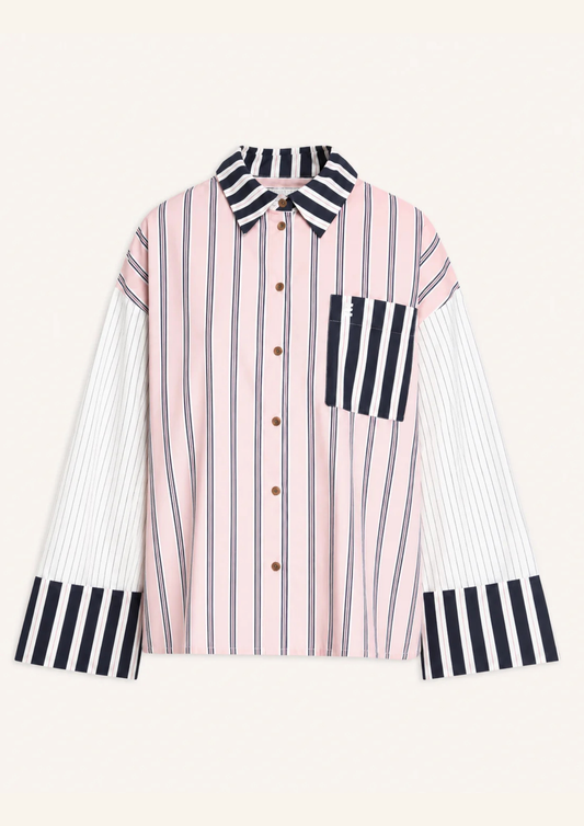 A long-sleeve button-up shirt with a pink and white vertical stripe body, contrasting black and white striped collar, chest pocket, and cuffs, displayed on a light cream background.
