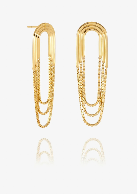 A pair of gold paperclip-shaped drop earrings with layered chain details, displayed on a clean white background with a soft reflection below.