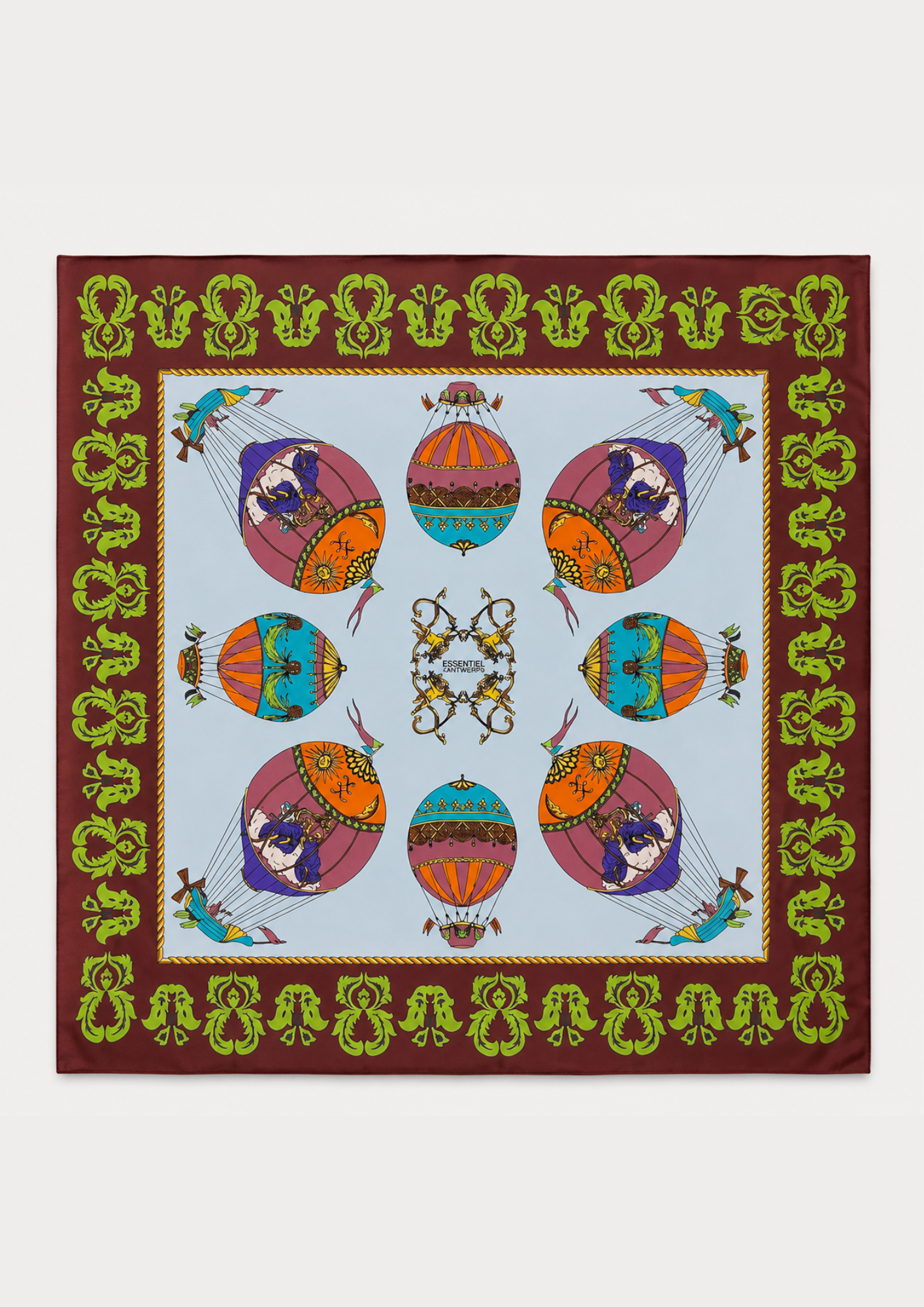 A square silk scarf featuring a colorful hot air balloon pattern on a light blue background, surrounded by a brown border with green and gold decorative motifs.