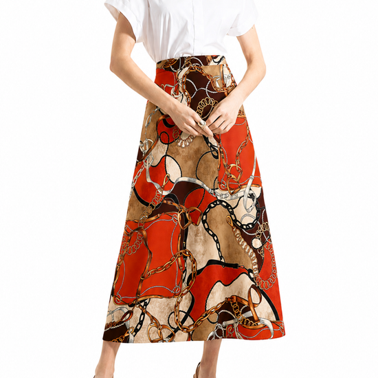 A model wearing a white short-sleeve button-up shirt and a high-waisted midi skirt with an abstract chain-link print in red, beige, and brown, paired with beige high-heeled sandals against a white background.