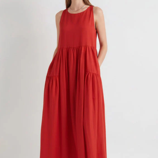 model wearing red tiered sundress on a white background