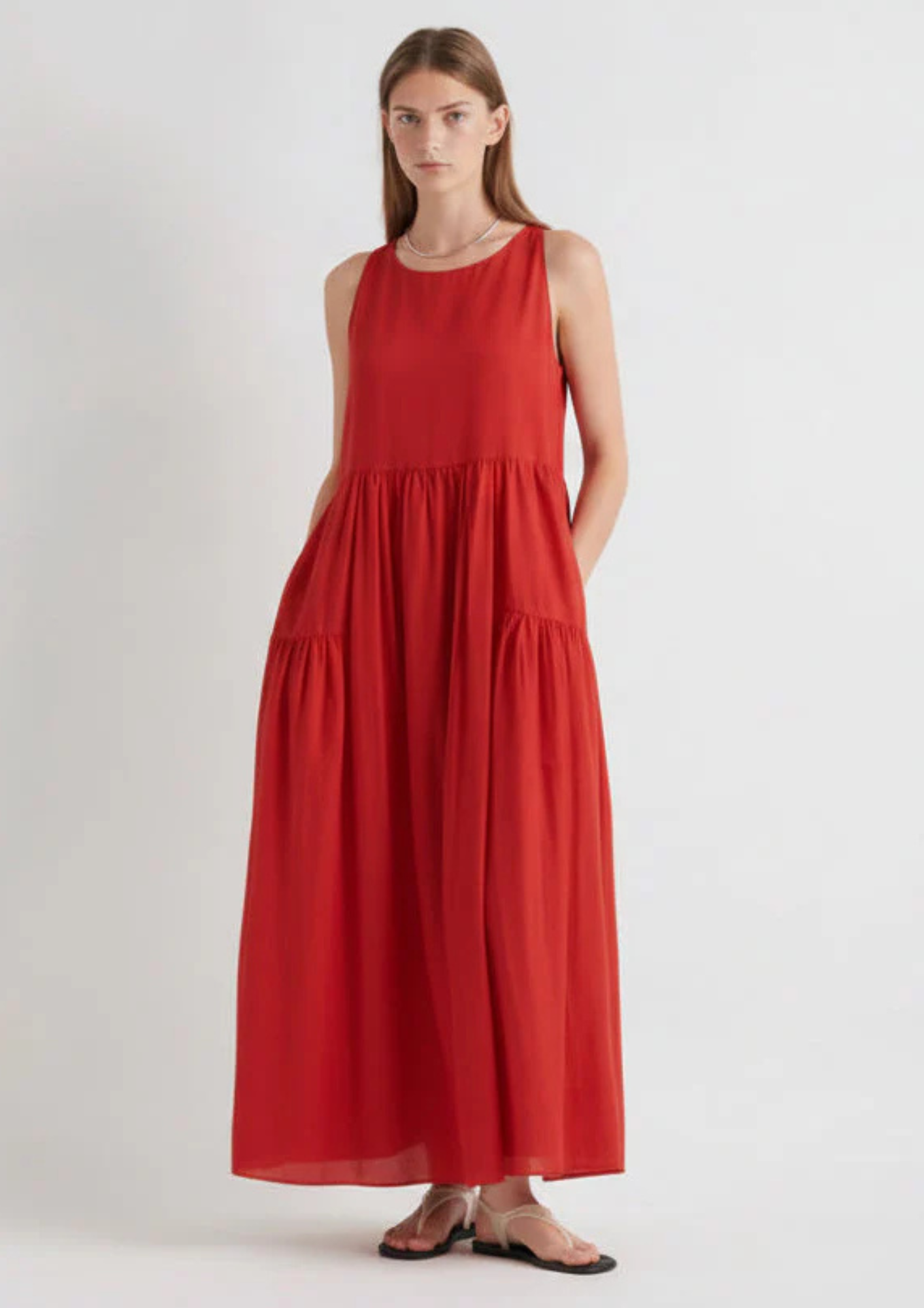 model wearing red tiered sundress on a white background