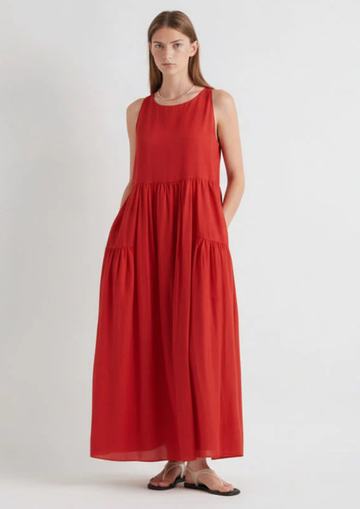model wearing red tiered sundress on a white background