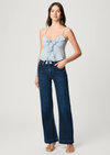 Woman wearing a light blue top and dark blue jeans on a white background