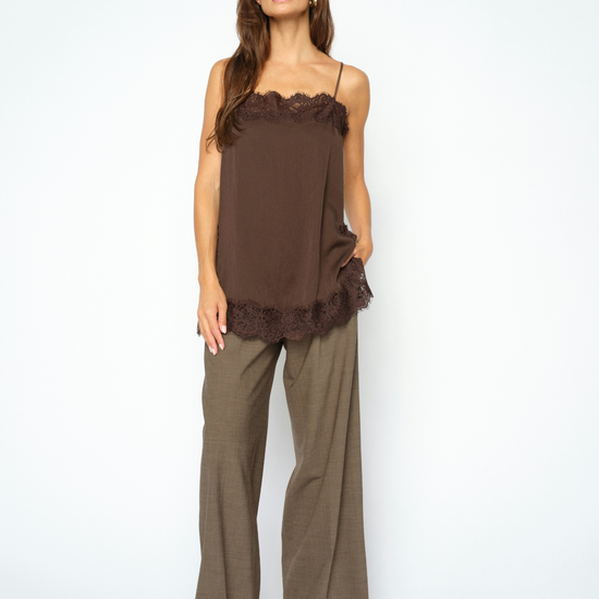 woman wearing brown lace cami and check trousers