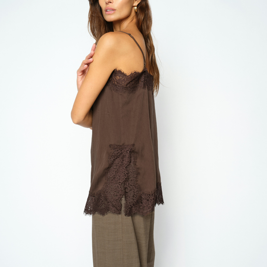 woman wearing brown lace cami and check trousers side view