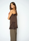 woman wearing brown lace cami and check trousers side view