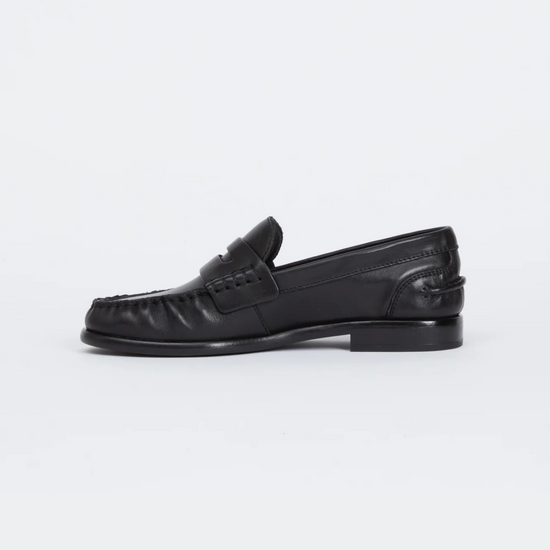 a side facing image of a black leather loafer on a plain background