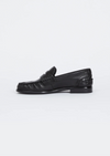 a side facing image of a black leather loafer on a plain background
