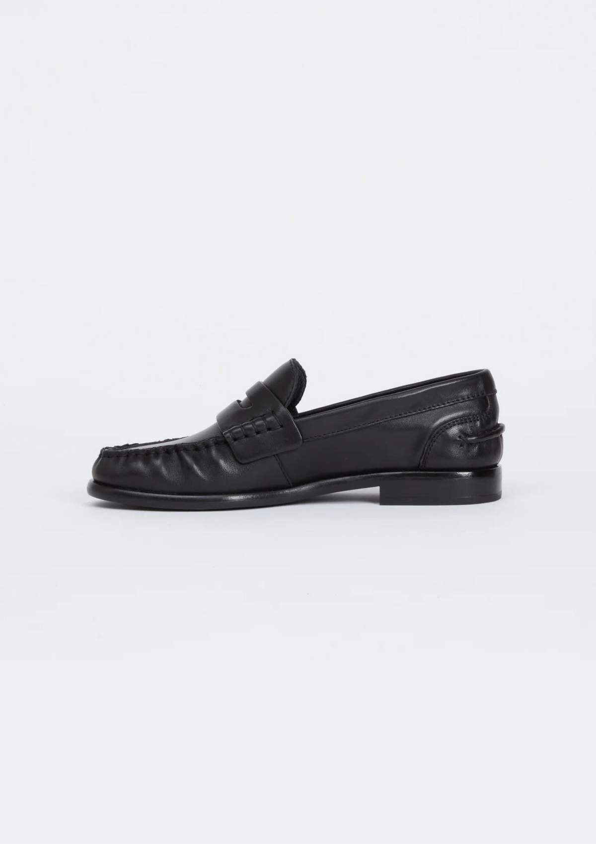a side facing image of a black leather loafer on a plain background