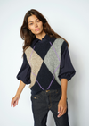 Woman wearing Blue, grey and beige Argyle vest with a blouse underneath