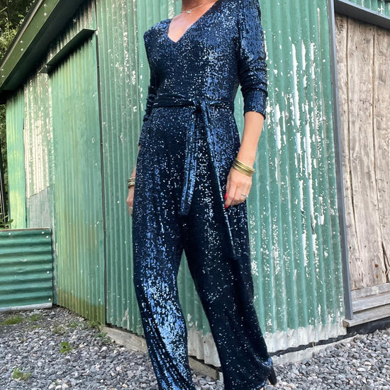 navy sequin jumpsuit with v neck, long sleeves and shoulder pads model shot