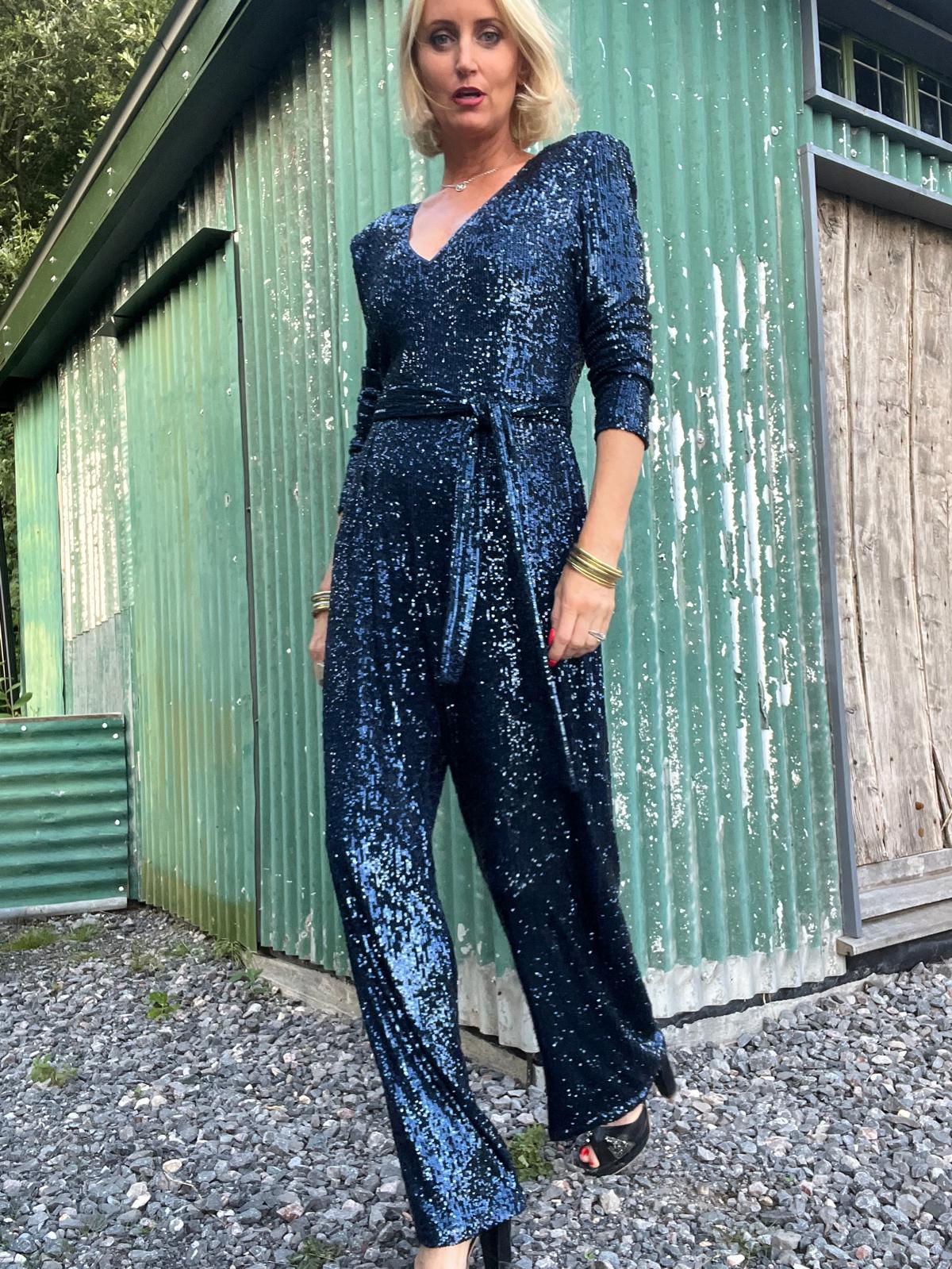 navy sequin jumpsuit with v neck, long sleeves and shoulder pads model shot