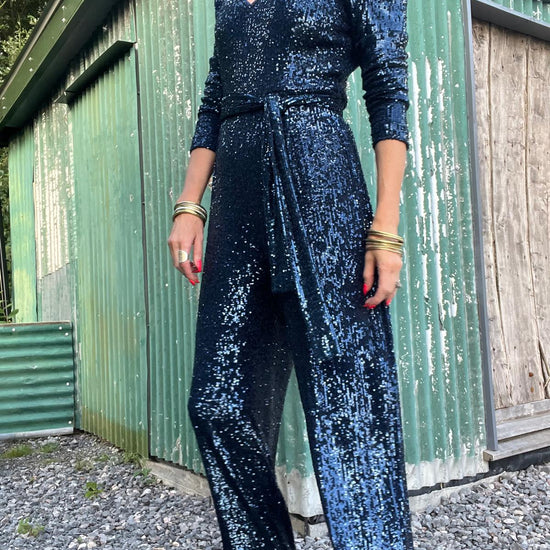 navy sequin jumpsuit with v neck, long sleeves and shoulder pads model shot