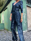 navy sequin jumpsuit with v neck, long sleeves and shoulder pads model shot