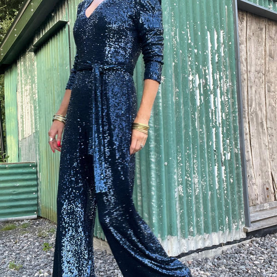 navy sequin jumpsuit with v neck, long sleeves and shoulder pads model shot