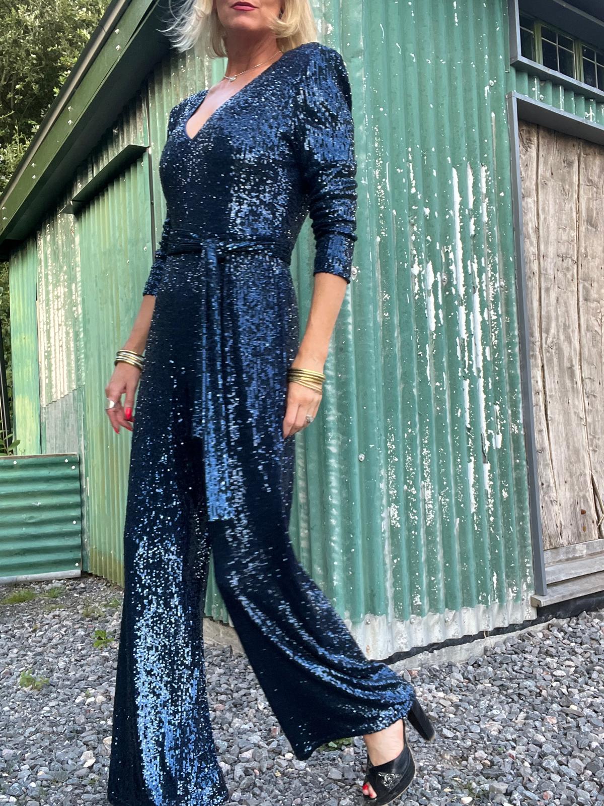 navy sequin jumpsuit with v neck, long sleeves and shoulder pads model shot