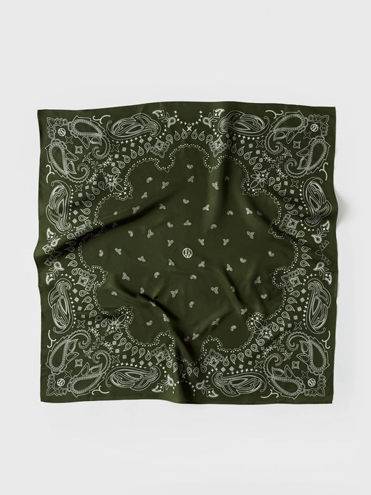 A green bandana with a white paisley and floral pattern, laid flat on a light gray background.