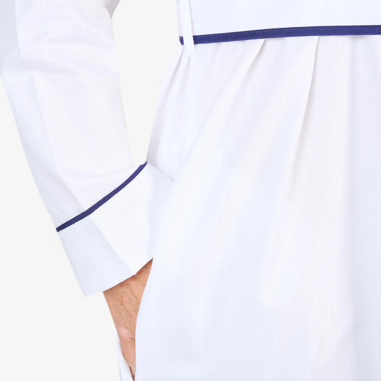 White herringbone organic cotton robe with navy trim long sleeves and front patch pocket