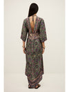 Woman wearing a patterned dress with a plain background