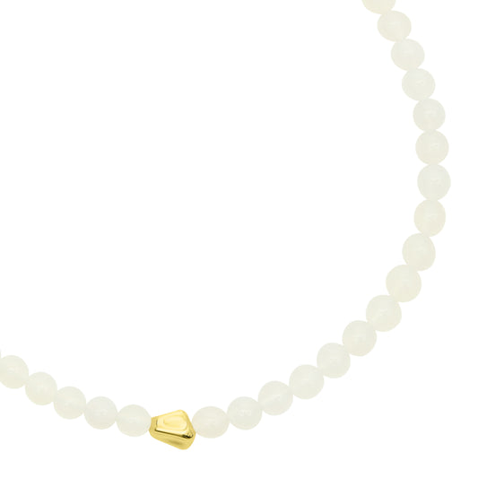 Necklace with white beads and a gold heart charm on a white background from Talis Chains