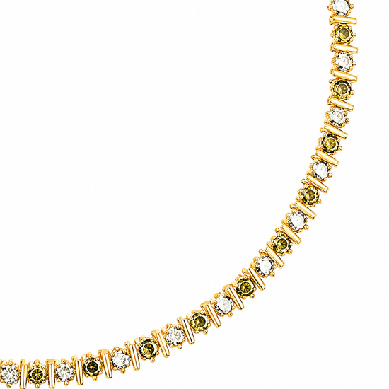 A gold tennis necklace featuring small green gemstones and clear stones, displayed on a clean white background. A gold tag is attached near the clasp.