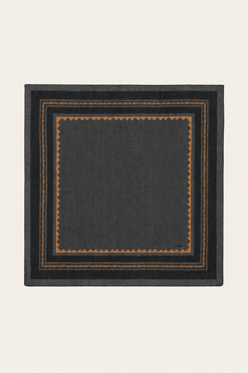 A square dark charcoal gray scarf with a geometric border pattern in brown and gold, displayed flat against a light cream background.