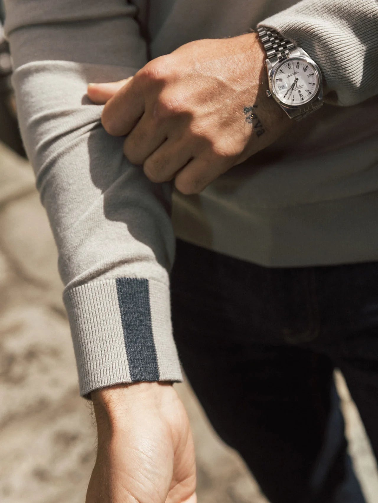 beige quarter zip knit with contrast stripe cuff close up on cuff