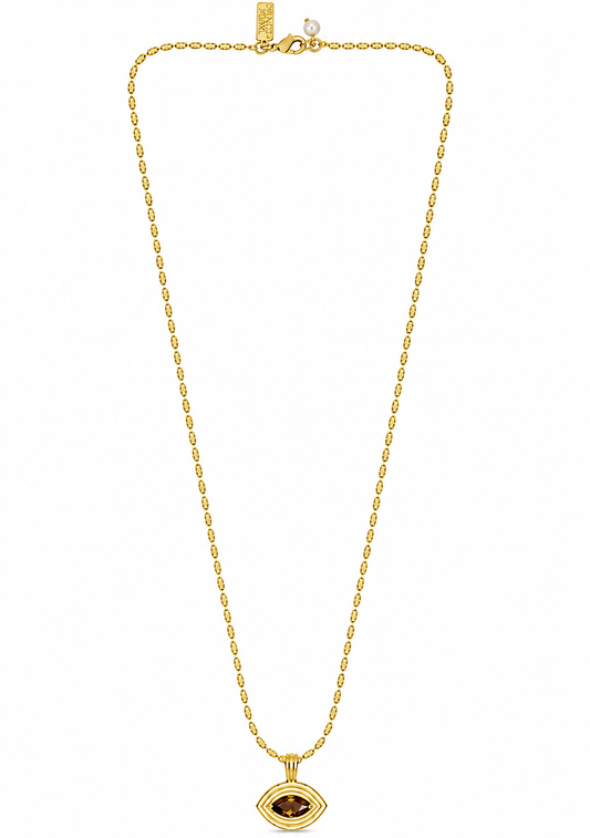 flat lay of a gold necklace with an evil eye pendant with a brown tigers eye stone on the pendant 