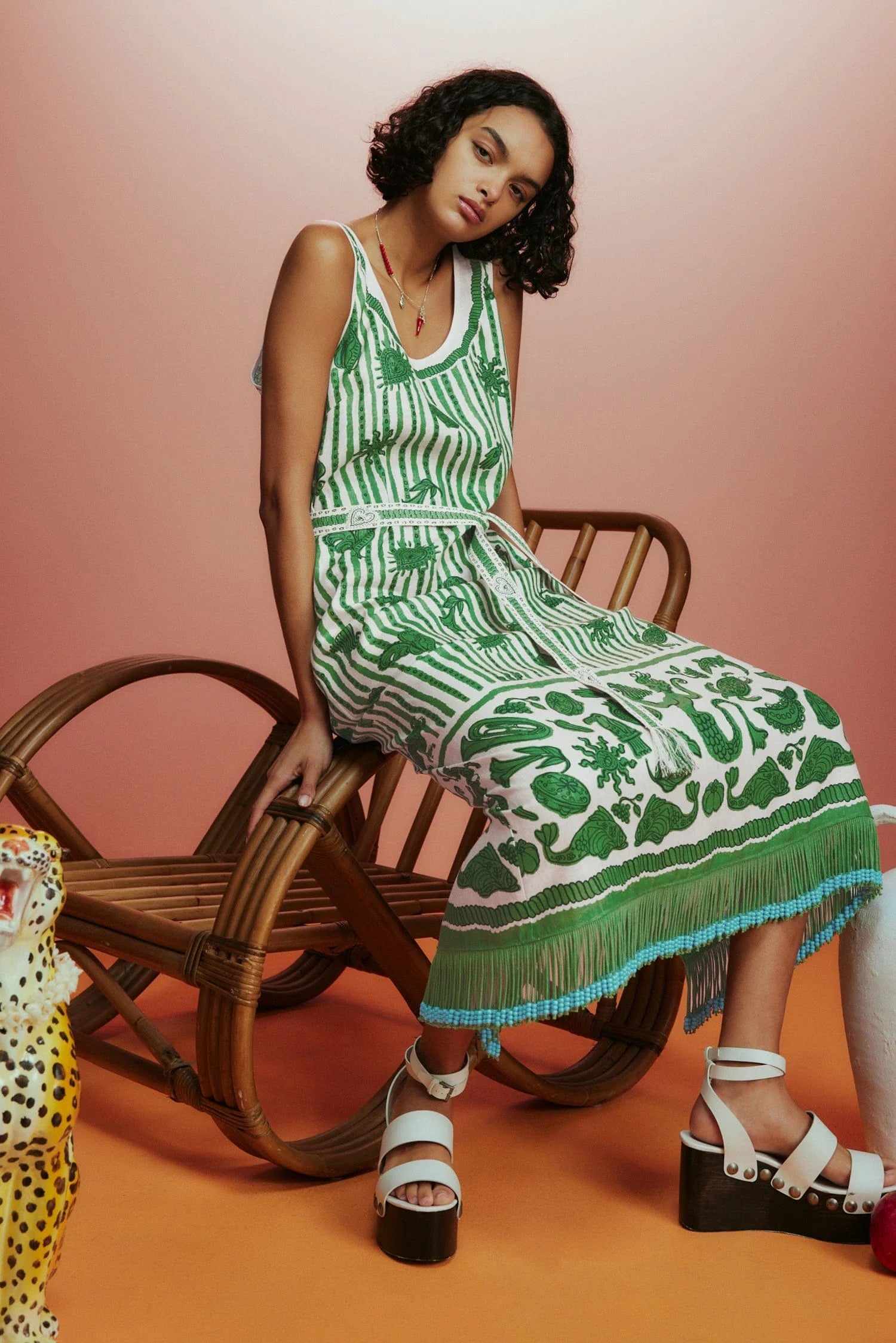 Sleeveless green printed sun dress with fringe detail on the hem