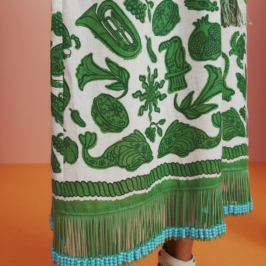 Sleeveless green printed sun dress with fringe detail on the hem close up