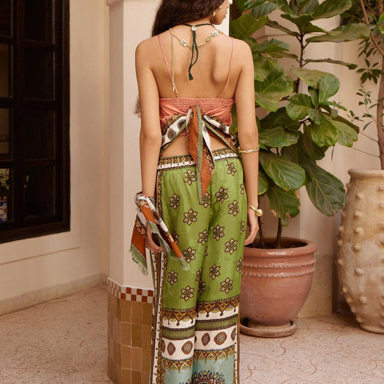 wide leg silk trousers with drawstring waistband and vibrant print from alemais rear view