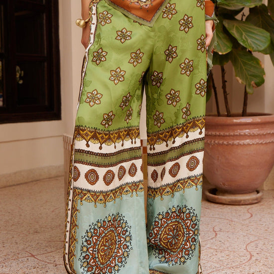 wide leg silk trousers with drawstring waistband and vibrant print from alemais model shot