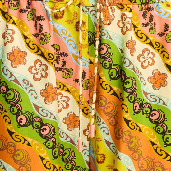 Colorful patterned shorts with a drawstring on a plain background