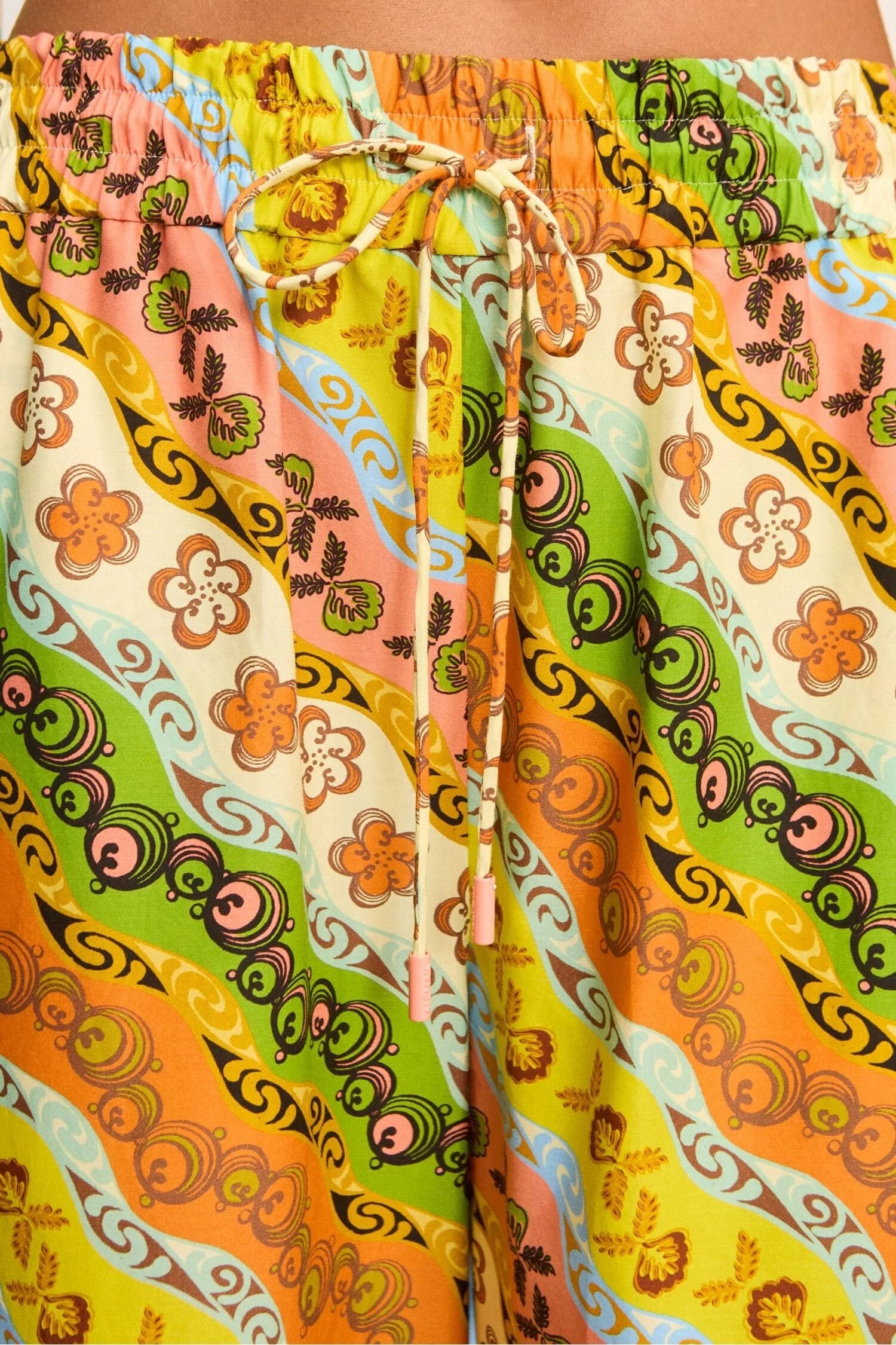 Colorful patterned shorts with a drawstring on a plain background