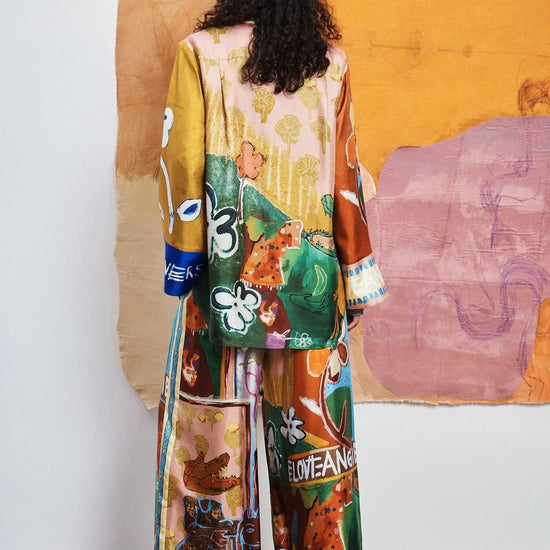 Colorful patchwork trousers with floral and abstract patterns by Alemais rear view