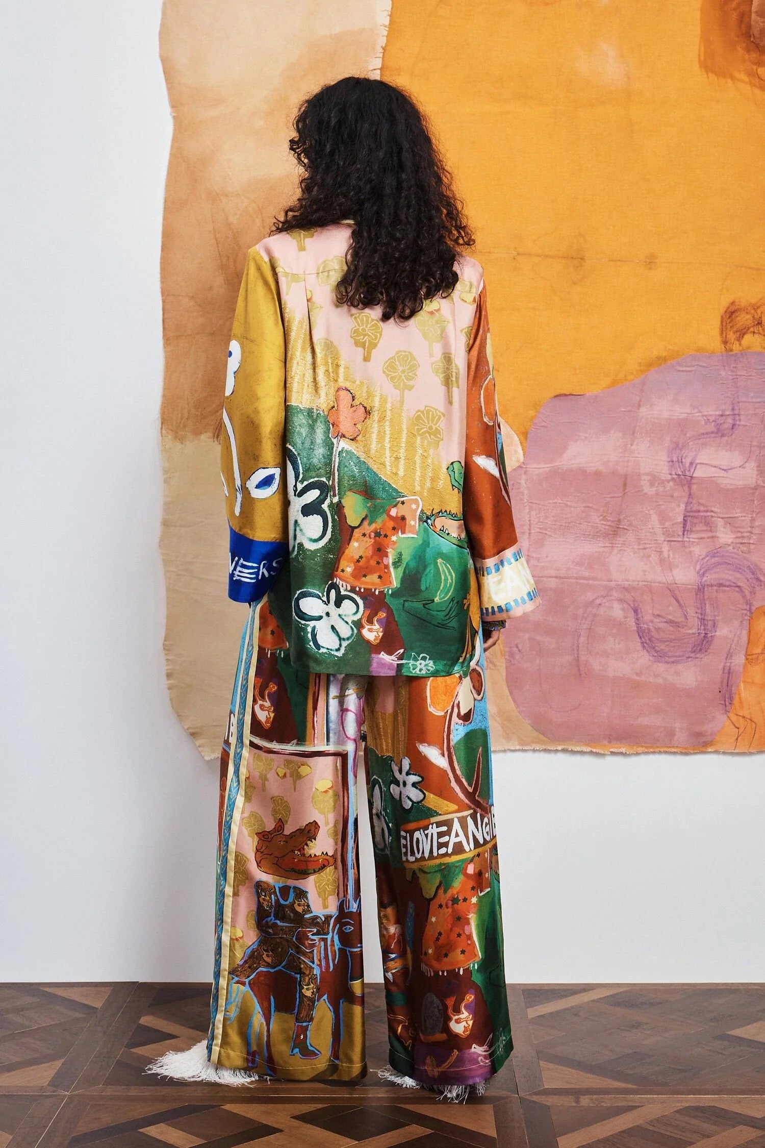Colorful patchwork trousers with floral and abstract patterns by Alemais rear view