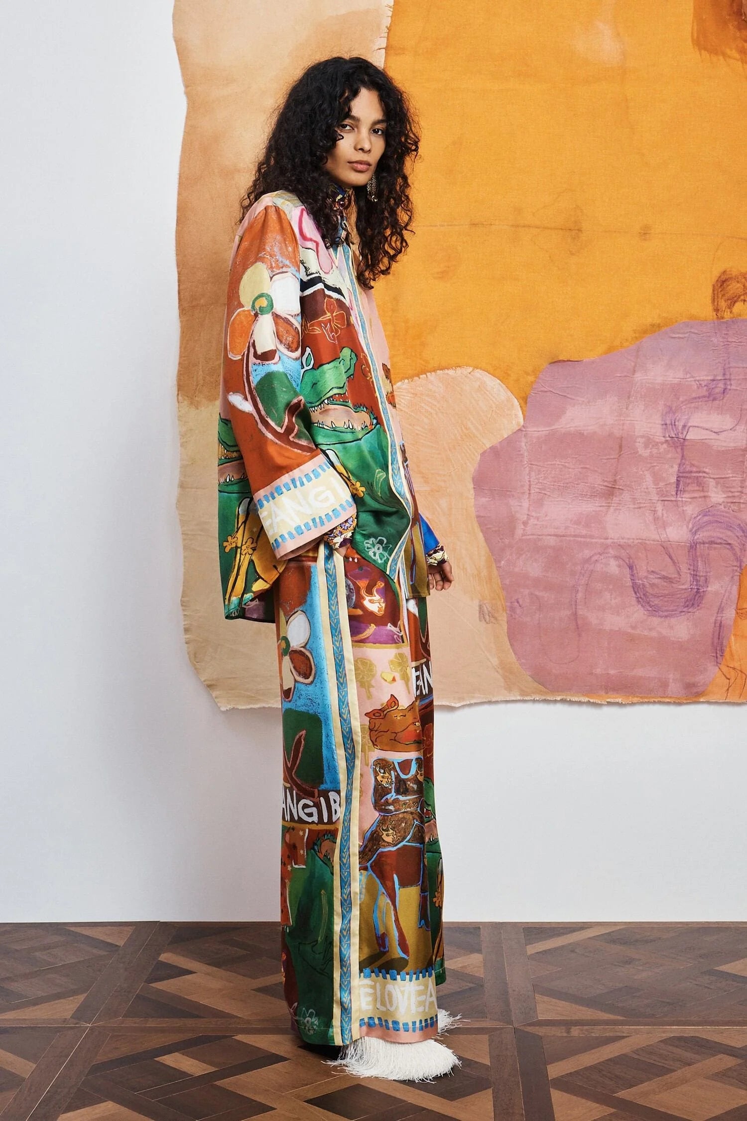 woman wearing Colourful patchwork trousers with floral and abstract patterns by Alemais side view