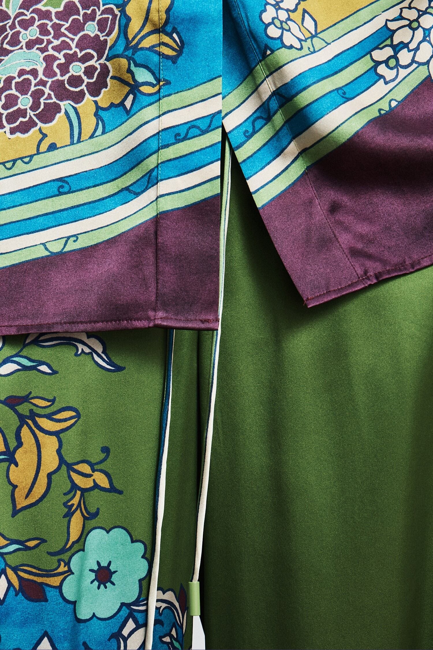 Close-up of a colorful fabric with floral patterns and stripes by Alemais.