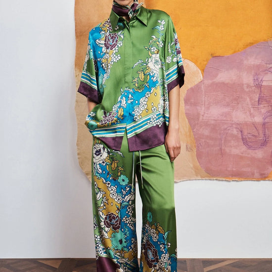 Woman wearing Green pants and shirt with colourful floral pattern By Alemais.