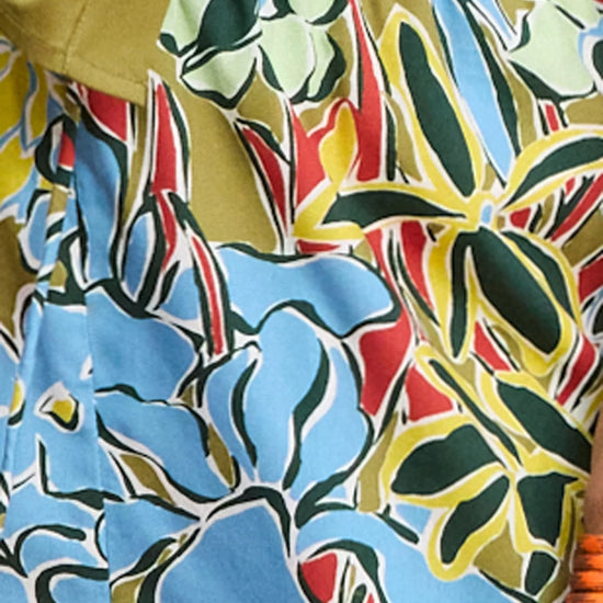 Close-up of a colorful floral patterned fabric with blue, red, green, and yellow colors.