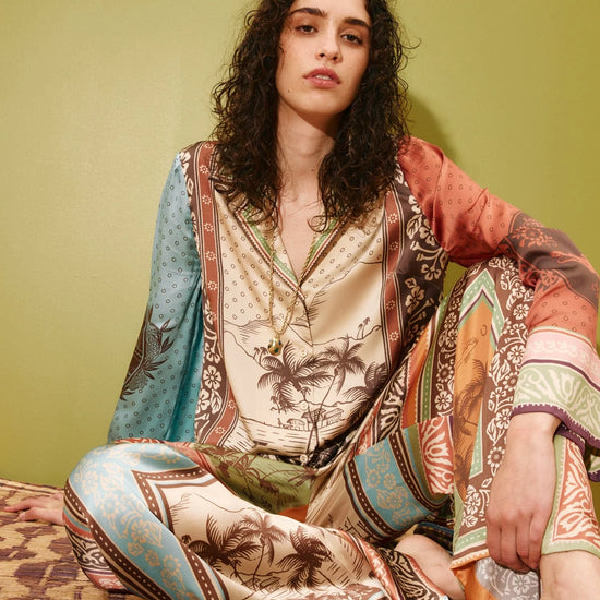 Model wearing matching long sleeve shirt with wide leg silk trousers from Alemais