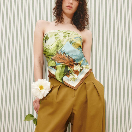 Square silk scarf worn as a top with trousers with a jungle print from Alemais