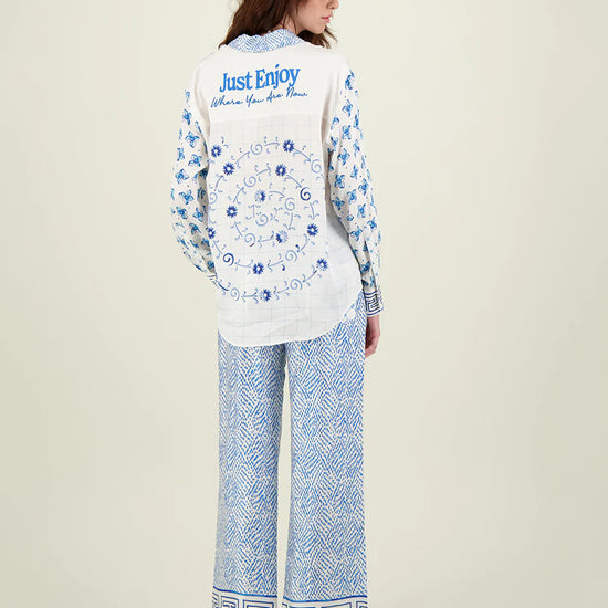 Blue and ivory patterned straight leg trousers with border hems and contrast fabric on the back