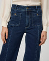 dark indigo wide leg jeans wit 2 front patch button pockets and front seam  close up